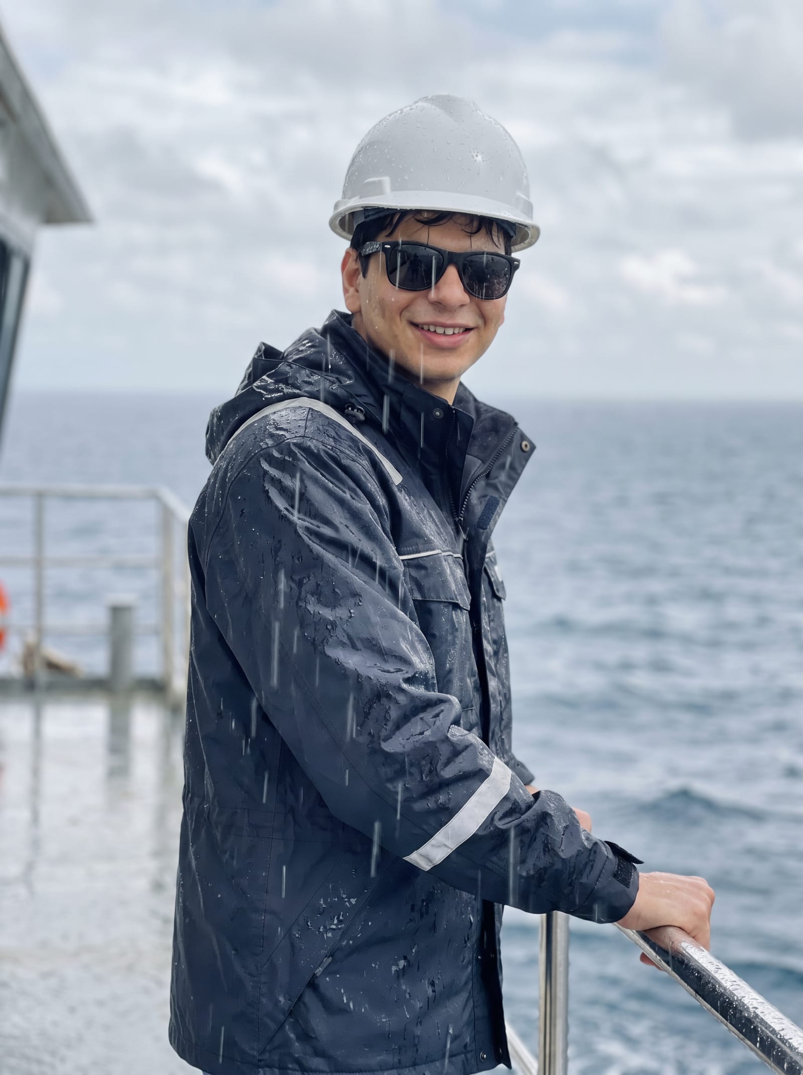Crew member at the rail of the vessel Pluto in heavy weather